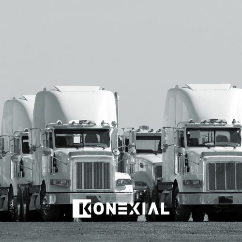Commercial fleet of black and white trucks lined up in parking lot
