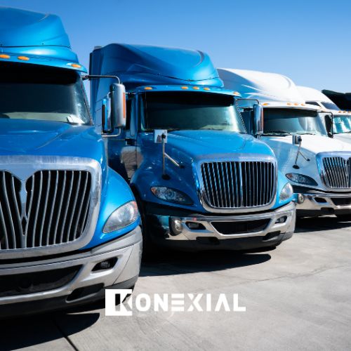 Commercial fleet of blue semi-trucks lined up in parking lot